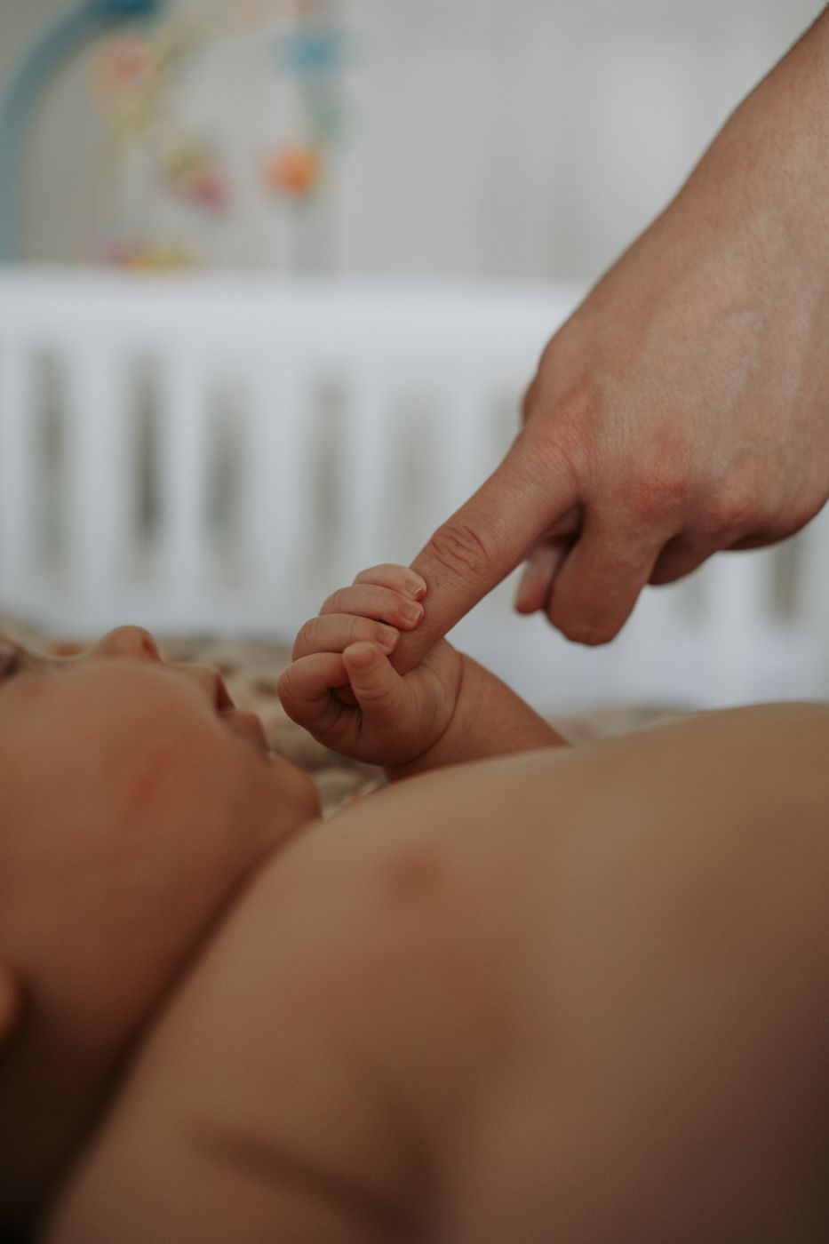 Newborn holding a parent's finger