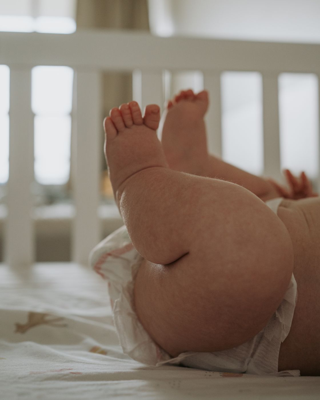 Newborn legs kicking in the crib