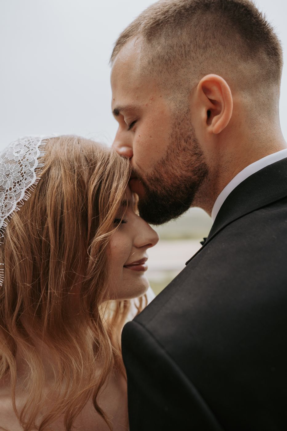 Groom kissing the bride on the forehead