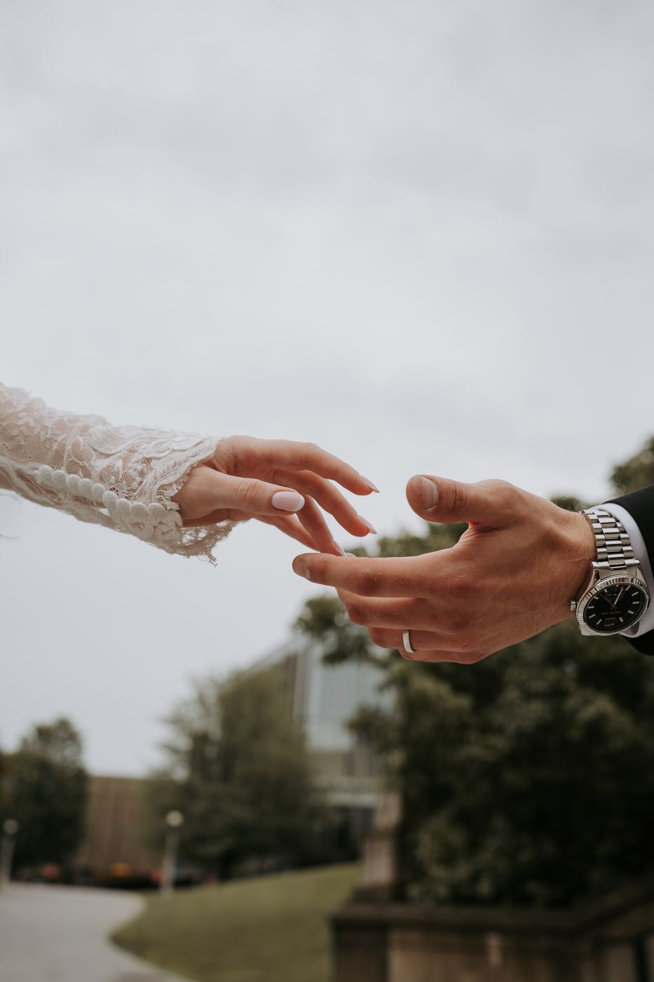 Bride and groom reaching for each other's hands