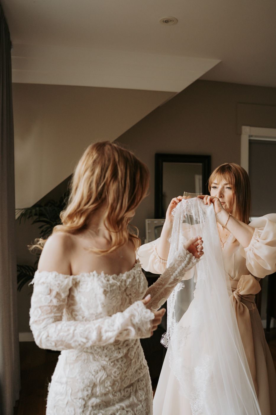 Mother of the bride placing the lace veil while getting ready
